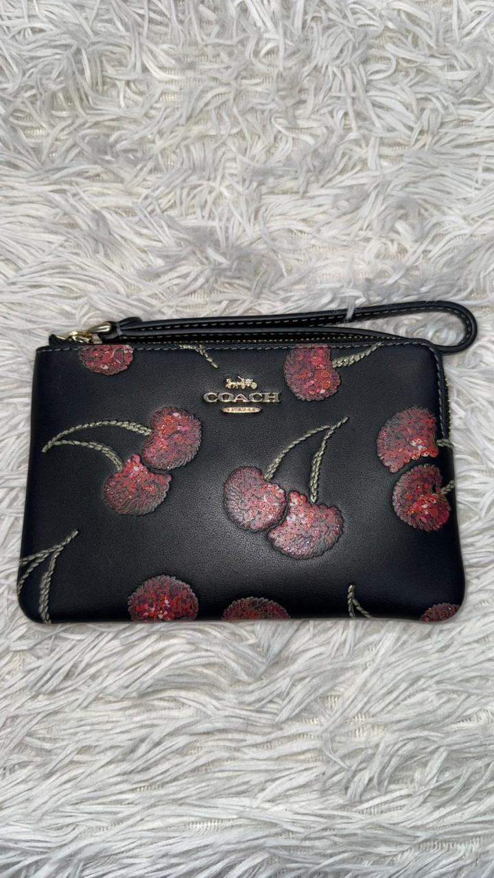 Muñequera negra con cerezas Coach